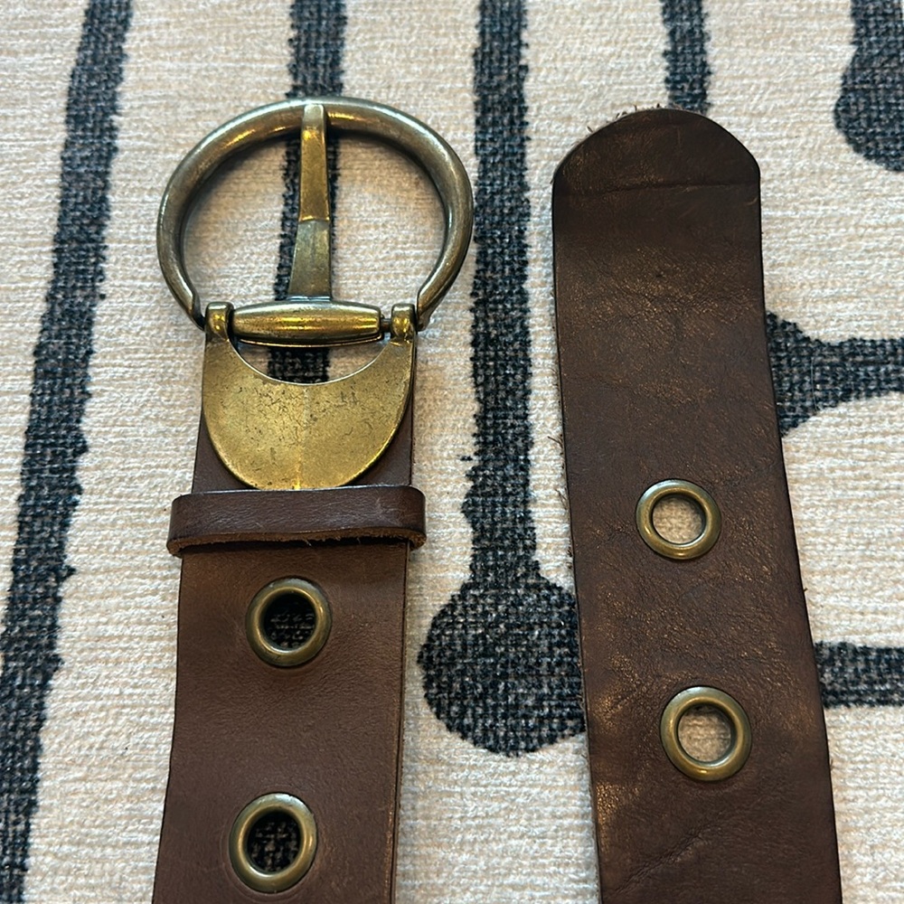 Brown leather belt with brass accents